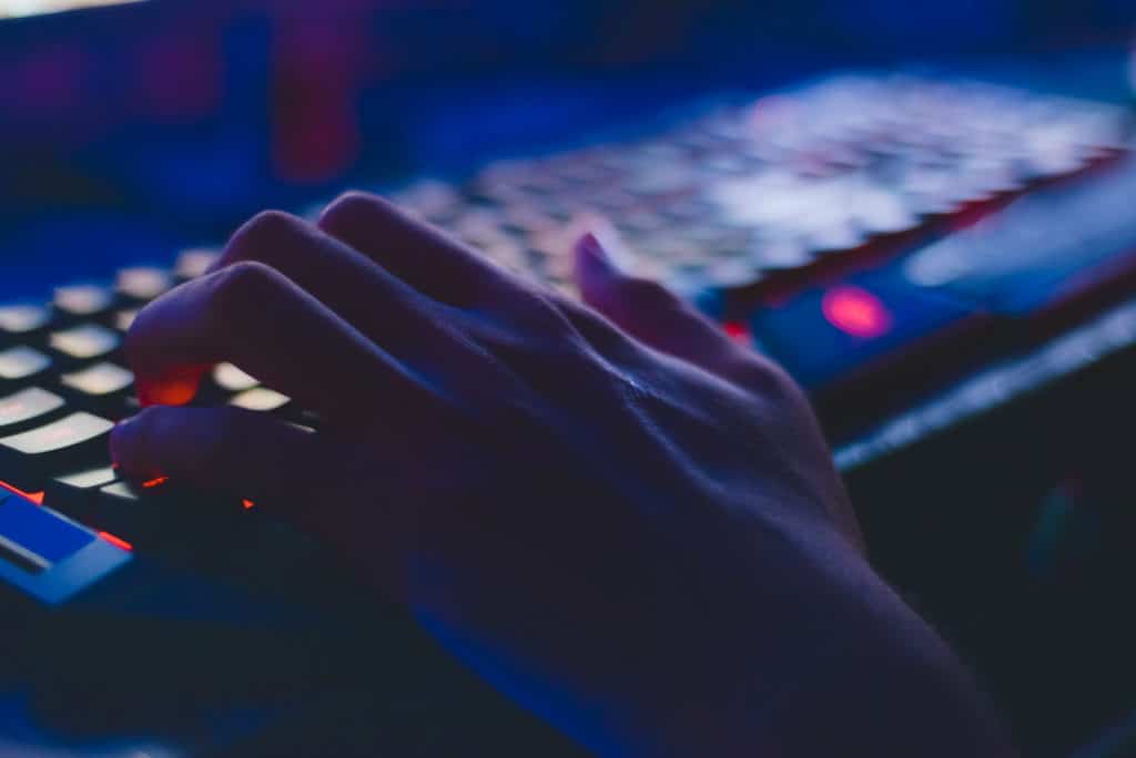 A imagem mostra uma mão sobre um teclado de computador.