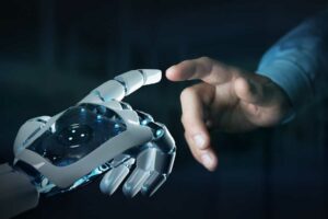 Dedo indicador de um homem toca o dedo indicador de um robô, trazendo o contexto da aplicação da inteligência artificial no mercado financeiro.