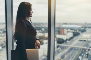 Mulher observa a cidade pela janela de vidro